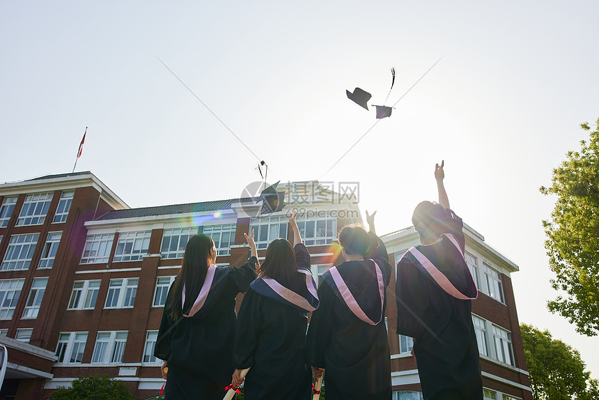 大学毕业生学士帽扔向空中背影图片