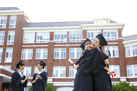 穿学士服的女大学生闺蜜拥抱图片