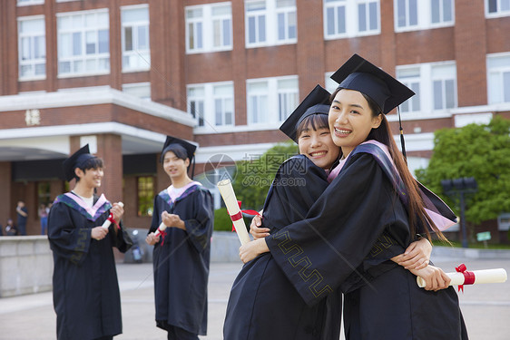 穿学士服的女大学生闺蜜拥抱图片