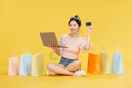 女子开心购物使用电脑网购刷卡的女子背景