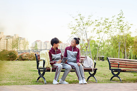 放学坐在长椅上聊天的小学生图片