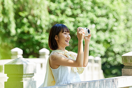 女生手拿相机夏日户外清新美女手拿相机背景