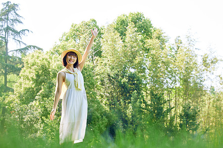 绿色长裙美女享受阳光室外散步夏日女性背景