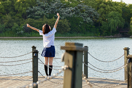 湖边散步站在湖边的校服女生背影背景