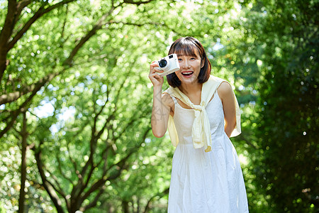 女生手拿相机夏日户外清新美女手拿相机形象背景