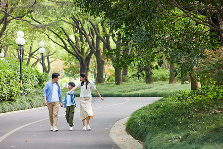 走路一家人在林荫道路散步背景