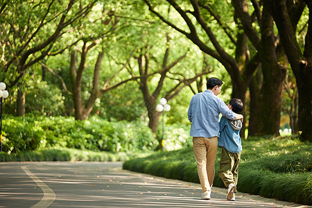 儿童走路父子在公园散步背影背景