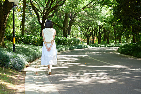 穿长裙的少女女孩夏日户外散步背影背景