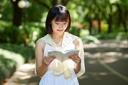 夏日户外看书的短发少女高清图片