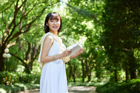 夏日户外看书的短发少女高清图片