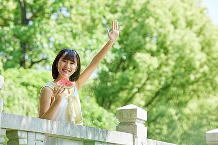 女孩夏日户外手拿西瓜打招呼图片