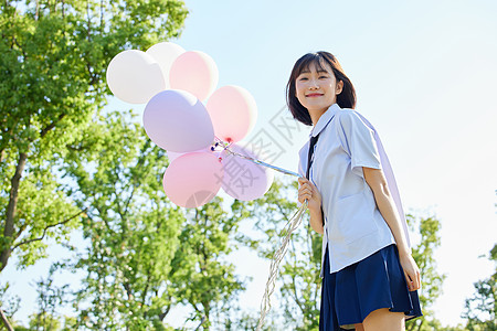 室外女学生手拿气球背景