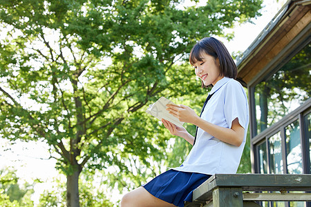 夏日美女阳光下看书的女学生背景