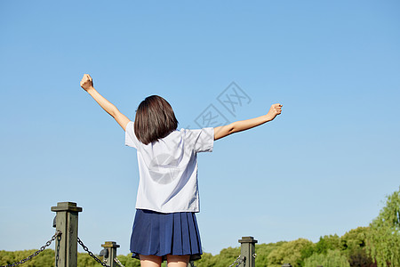 阳光少女毕业季校服女生举手背影背景