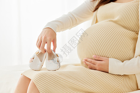 孕妇妈妈手拿宝宝鞋特写图片