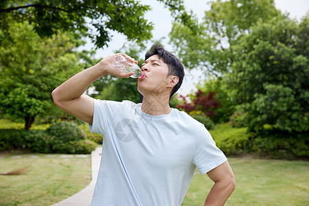 夏天户外大口喝水的男性图片