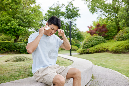 男子打电话男子在公园出汗擦汗背景