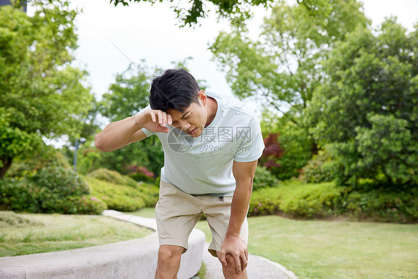 闷热的天气男子擦汗休息图片