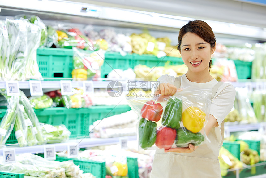 店员展示超市里的新鲜彩椒图片