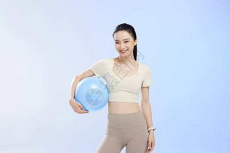 运动少女手拿瑜伽球佩戴电子手表图片