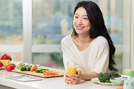 女性手捧橙汁在餐桌边形象高清图片