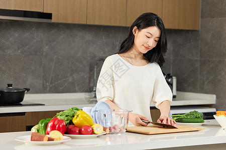 女人将案板上的肉放到破壁机里图片