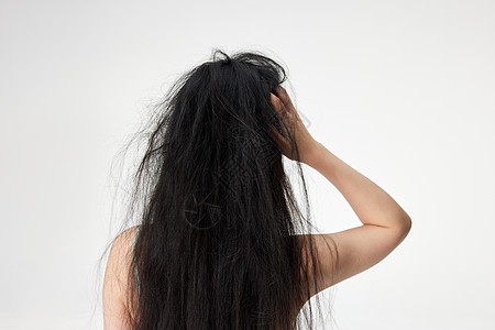 黑发女人抓挠头发的女性形象背景