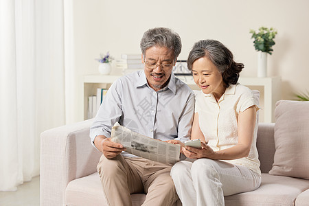 沙发上一起看报纸的老夫妻图片