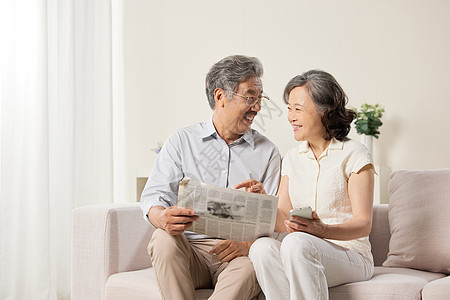 沙发上休闲看报纸的老夫妻图片