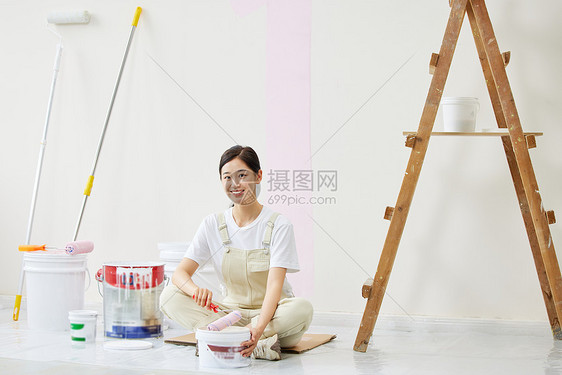 女人盘坐着调试油漆形象图片