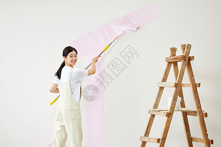 女子使用工具刷墙壁形象图片