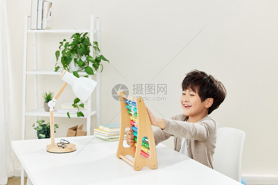 书桌上玩智力玩具的小男孩图片