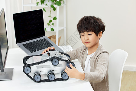 温馨居家电脑桌前研究科技设备的小男孩背景