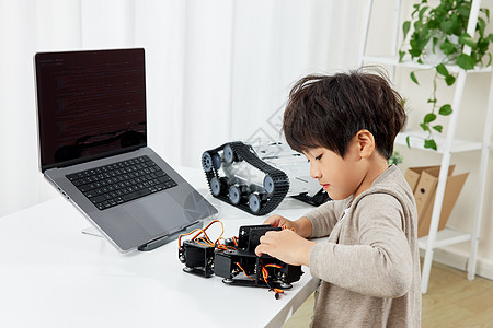 电脑桌前研究装置的小男孩图片