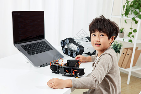 电脑桌前研究装置的男孩形象图片