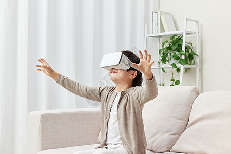 虚拟技术沙发上戴VR眼镜的男孩背景
