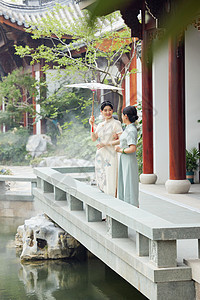 下雨天在中式庭院撑伞的旗袍母女图片