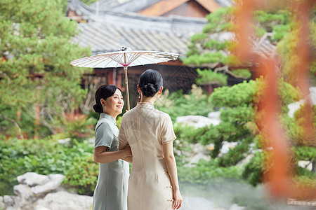 下雨天在中式庭院撑伞的旗袍母女图片