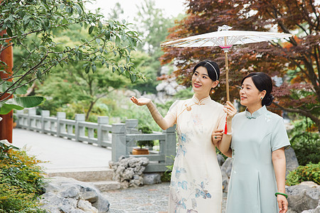 雨中穿旗袍的母女欣赏庭院美景图片