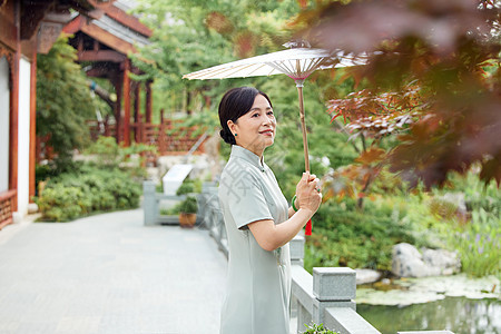 户外撑伞的中年女性图片