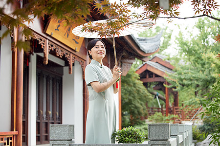 雨中庭院欣赏美景的中年女性图片