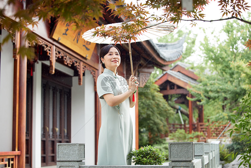 雨中庭院欣赏美景的中年女性图片