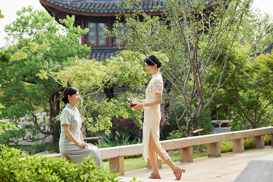 院子里吃点心喝茶的旗袍母女图片