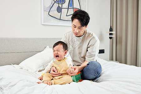 小孩子哭泣疲惫的父亲节假日居家照顾小宝宝背景