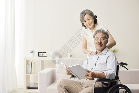 奶奶陪伴着轮椅上的爷爷阅读图片