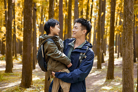 树林里抱着孩子的父亲形象图片
