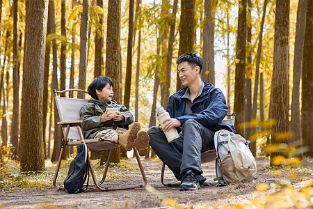 父子背影坐在树林里休息的父子背景