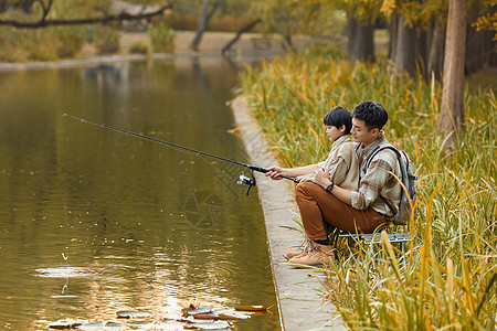 坐在河边钓鱼的父子形象背景图片