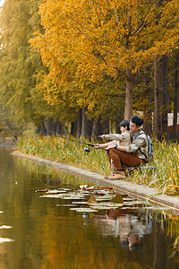 坐在河边钓鱼的父子背景图片