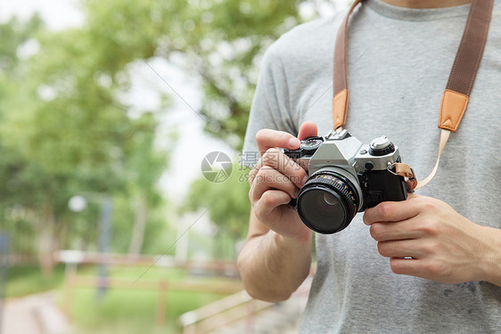 户外男性手拿相机特写图片